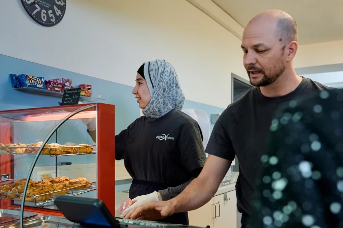 Ein Betreuer und eine Teilnehmerin arbeiten im Schulbuffet